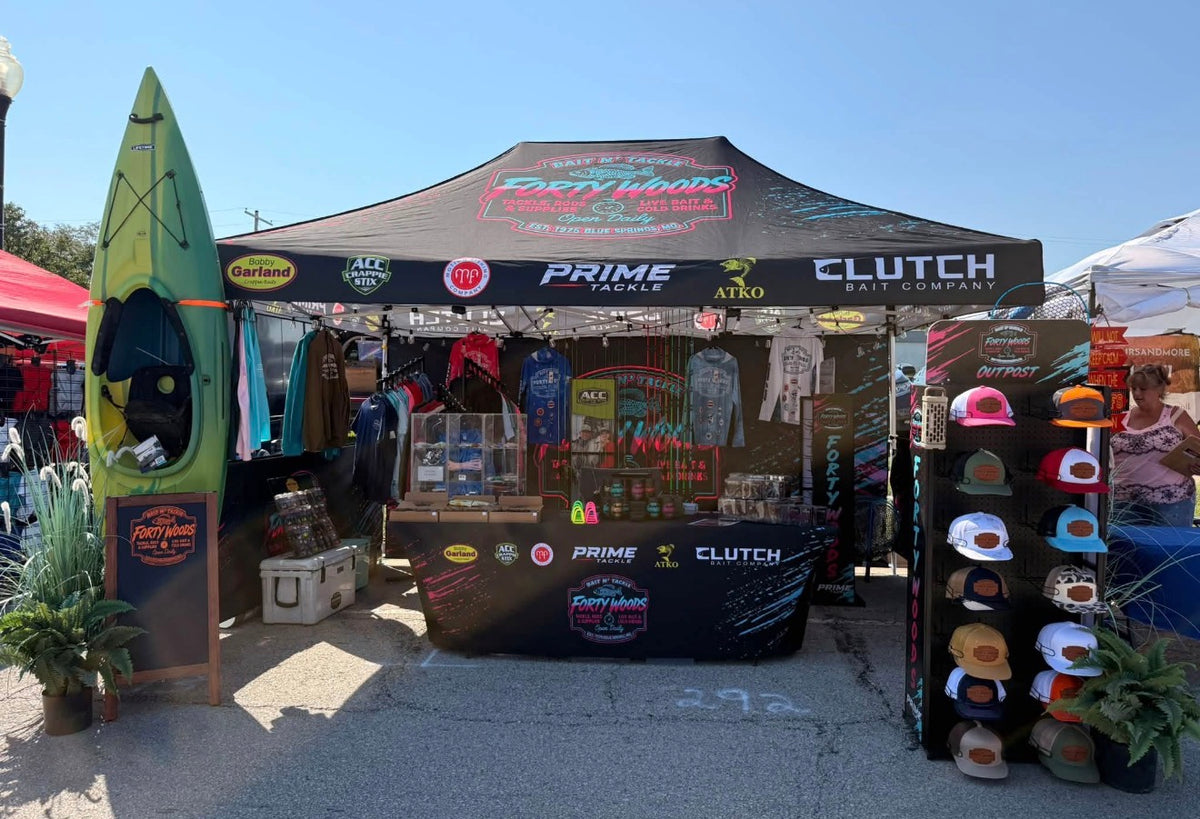 Forty Woods event tent with tackle, apparel, hats and a kayak.